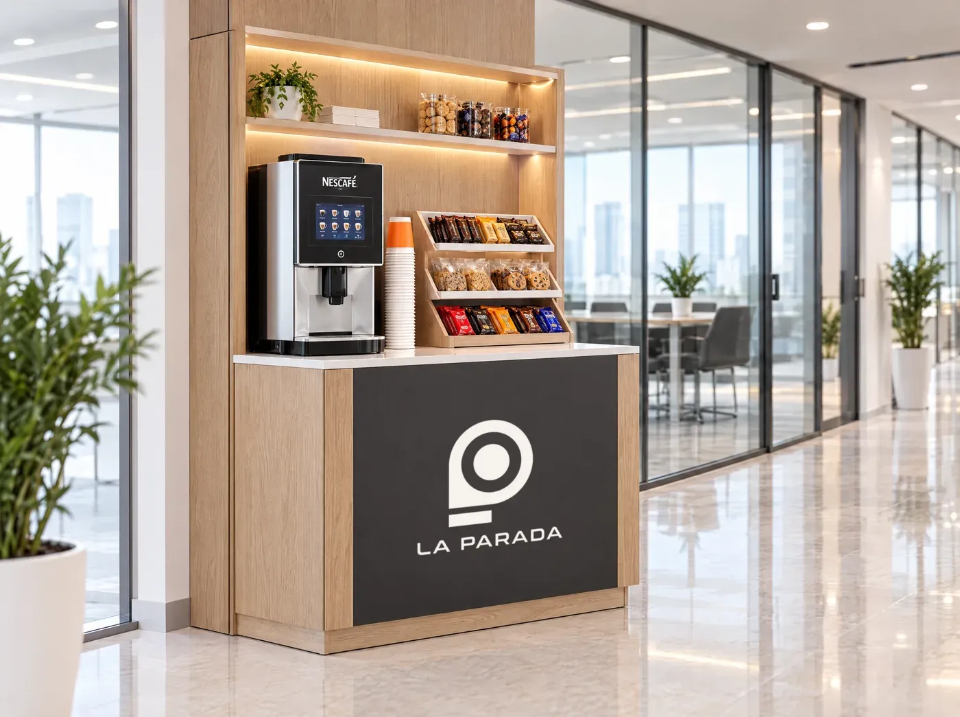 Punto compacto de La Parada con café Nescafé y snacks en un pasillo corporativo